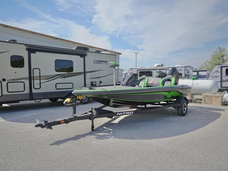 Slide: The Image of Nitro Z18 2025 boat on trailer, parked near RVs under a clear sky. - 1