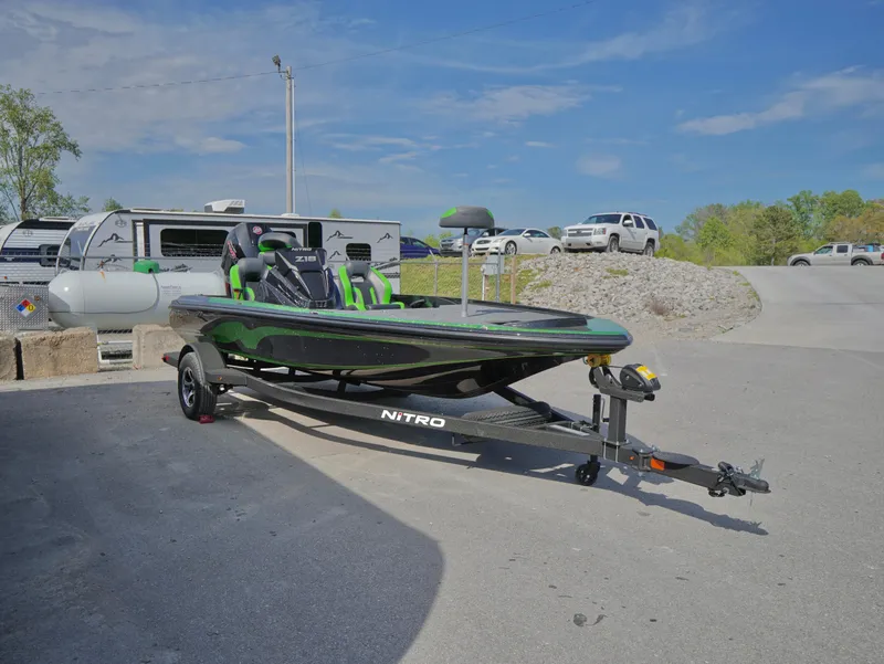 Slide: The Image of 2025 Nitro Z18 boat on trailer in parking lot under clear blue sky. - 16