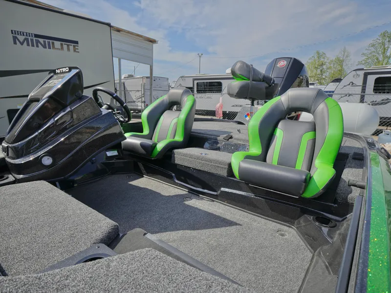 Slide: The Image of 2025 Nitro Z18 boat interior with green and black seats, parked near RVs. - 6
