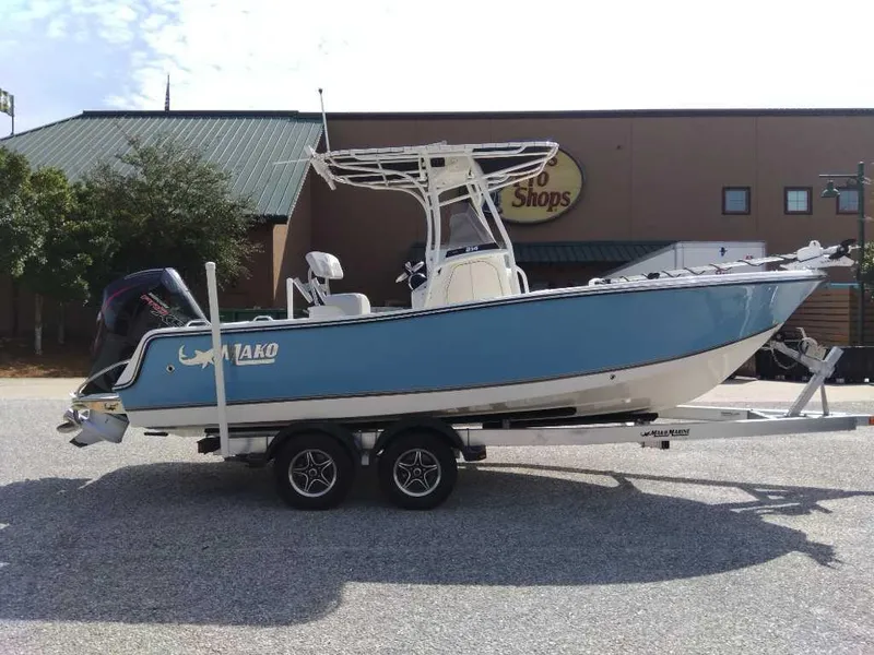 Slide: The Image of 2024 Mako 214 CC boat on trailer, parked outside a building. - 0