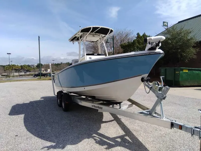 Slide: The Image of 2024 Mako 214 CC boat on trailer, parked outdoors under clear sky. - 1