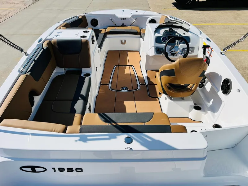 Slide: The Image of 2024 Tahoe 1950 boat interior with tan and black seating, steering console, and spacious layout. - 10