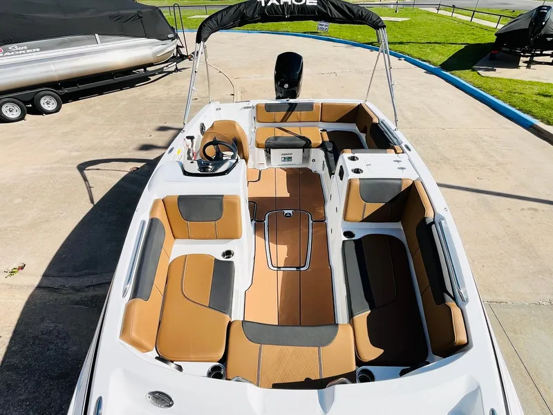 Slide: The Image of 2024 Tahoe 1950 boat with tan and gray seating, docked on concrete. - 14