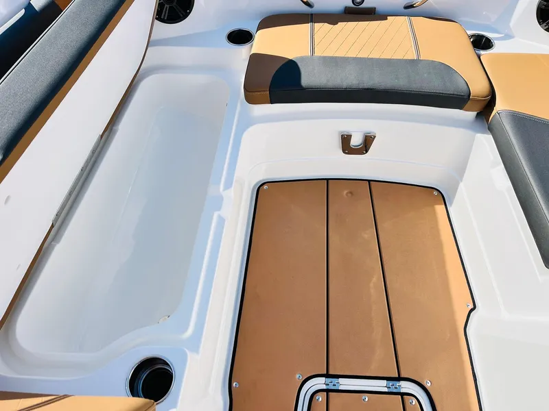 Slide: The Image of 2024 Tahoe 1950 boat interior with tan and black seating and storage compartments. - 16