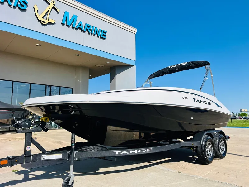Slide: The Image of 2024 Tahoe 1950 boat on trailer outside dealership under clear blue sky. - 2