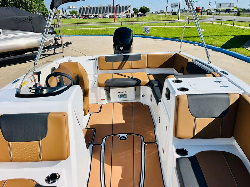 Slide: The Image of 2024 Tahoe 1950 boat interior with tan and gray seating, steering wheel, and open deck. - 20