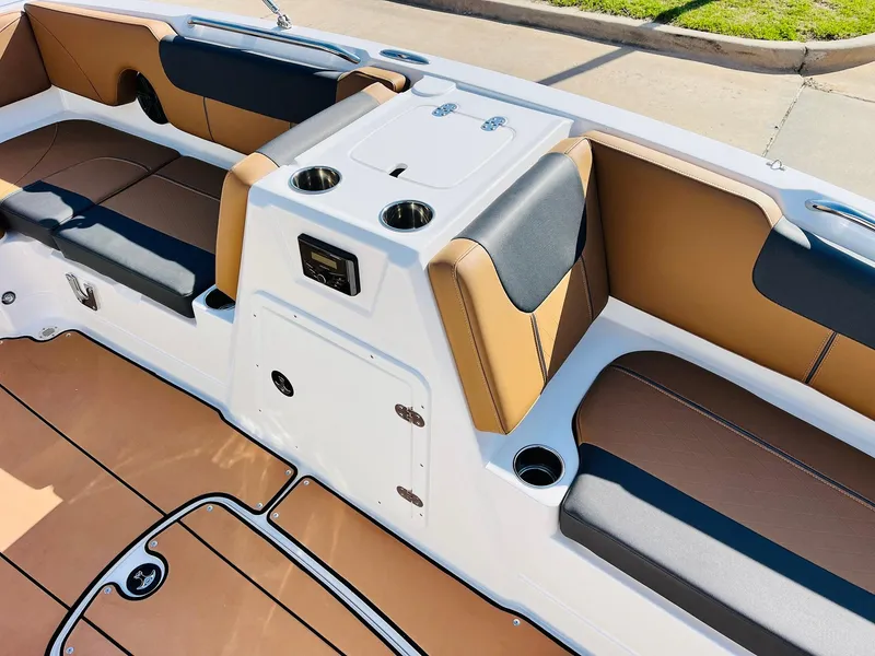 Slide: The Image of 2024 Tahoe 1950 boat interior with tan and black seating, cup holders, and storage compartments. - 21
