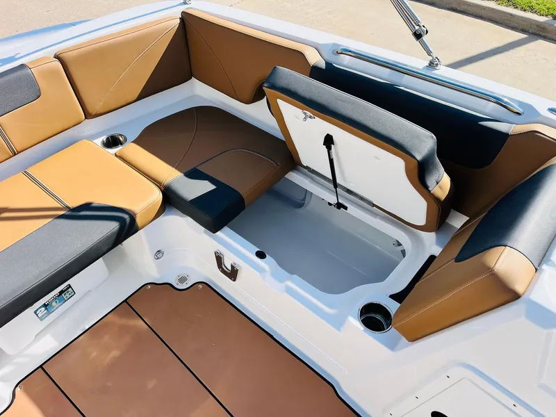 Slide: The Image of 2024 Tahoe 1950 boat interior with tan and black seating, open storage compartment. - 26