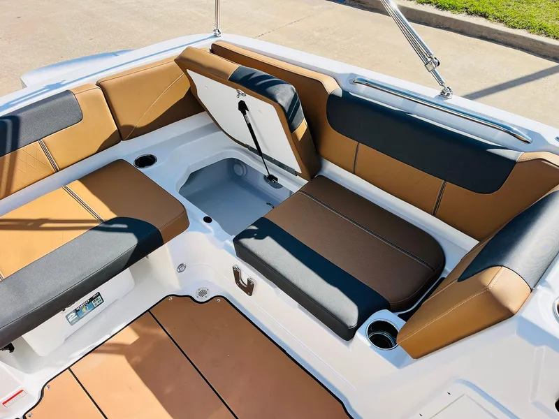 Slide: The Image of 2024 Tahoe 1950 boat interior with tan and black seating, storage compartment, and cup holders. - 27