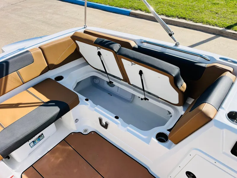 Slide: The Image of 2024 Tahoe 1950 boat interior with tan and black seating, open storage compartments. - 28
