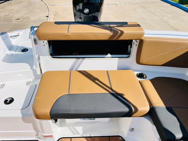 Slide: The Image of 2024 Tahoe 1950 boat seating area with tan and black cushions, featuring storage compartment. - 30