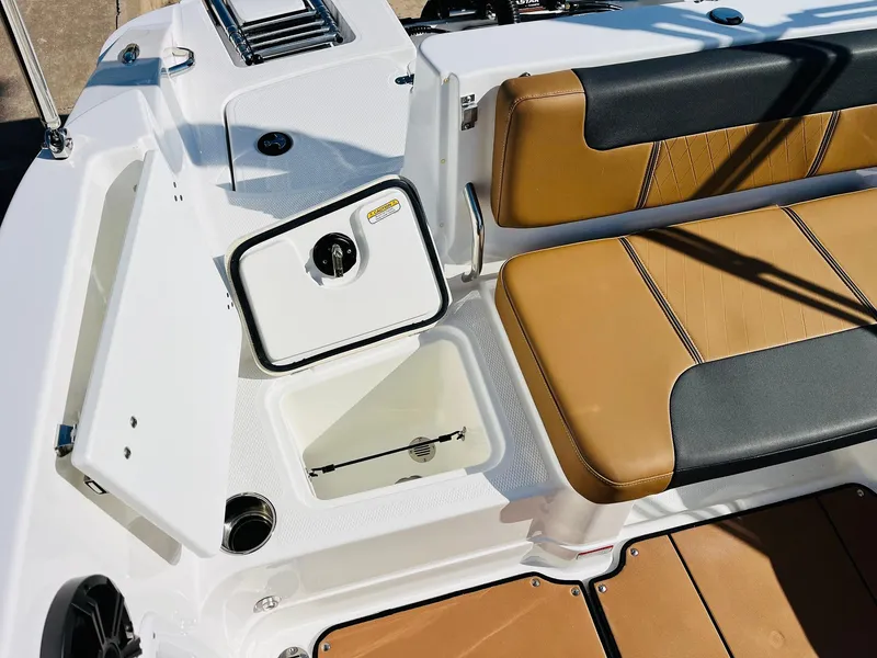 Slide: The Image of 2024 Tahoe 1950 boat interior with tan and black seating, storage compartment open. - 36