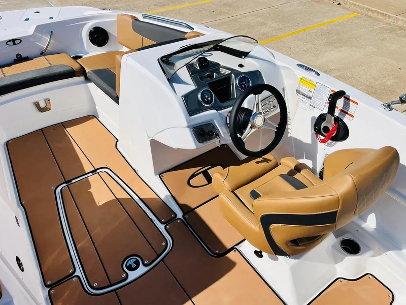 Slide: The Image of 2024 Tahoe 1950 boat interior with tan seating and modern dashboard controls. - 37