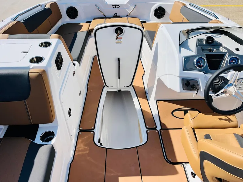 Slide: The Image of 2024 Tahoe 1950 boat interior with tan and white seating, storage, and steering console. - 38