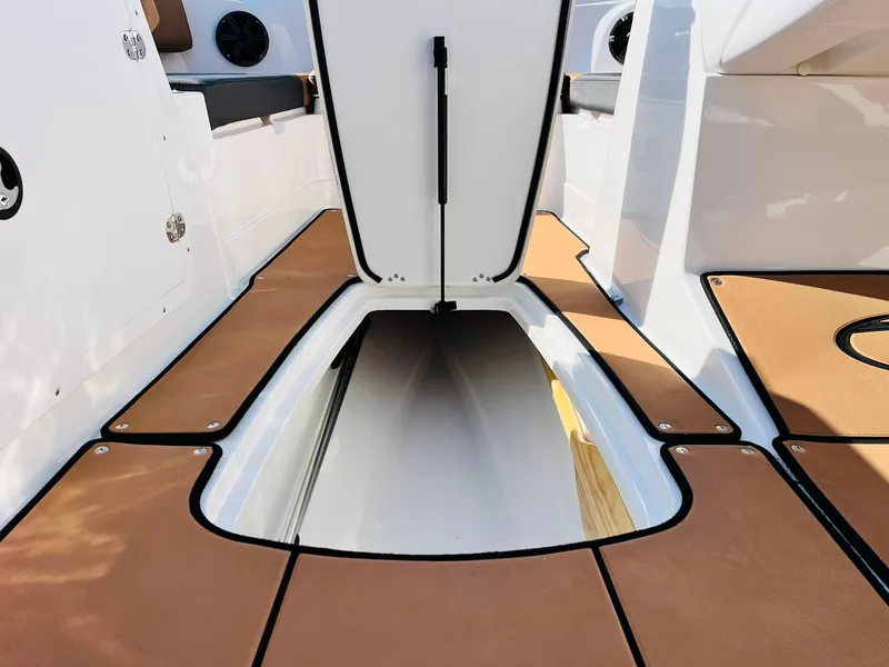 Slide: The Image of 2024 Tahoe 1950 boat interior with open storage compartment and brown deck. - 39