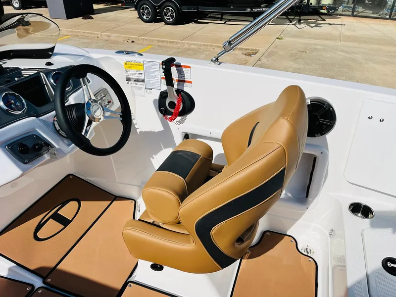 Slide: The Image of 2024 Tahoe 1950 boat interior with tan and black seating, steering wheel, and dashboard controls. - 42
