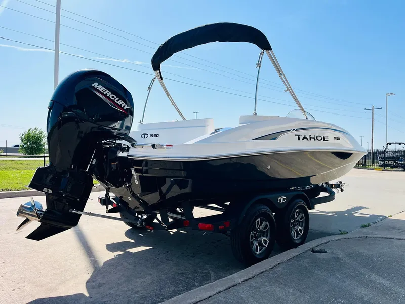 Slide: The Image of 2024 Tahoe 1950 boat with Mercury engine on trailer, parked outdoors. - 6