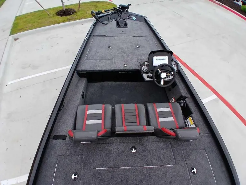 Slide: The Image of 2025 Ranger RT188 boat interior with steering console and seating, parked on concrete. - 5