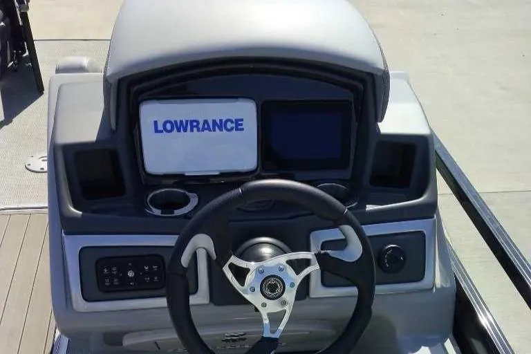 Slide: The Image of 2024 Regency 230 DL3 boat dashboard with Lowrance display and steering wheel. - 4