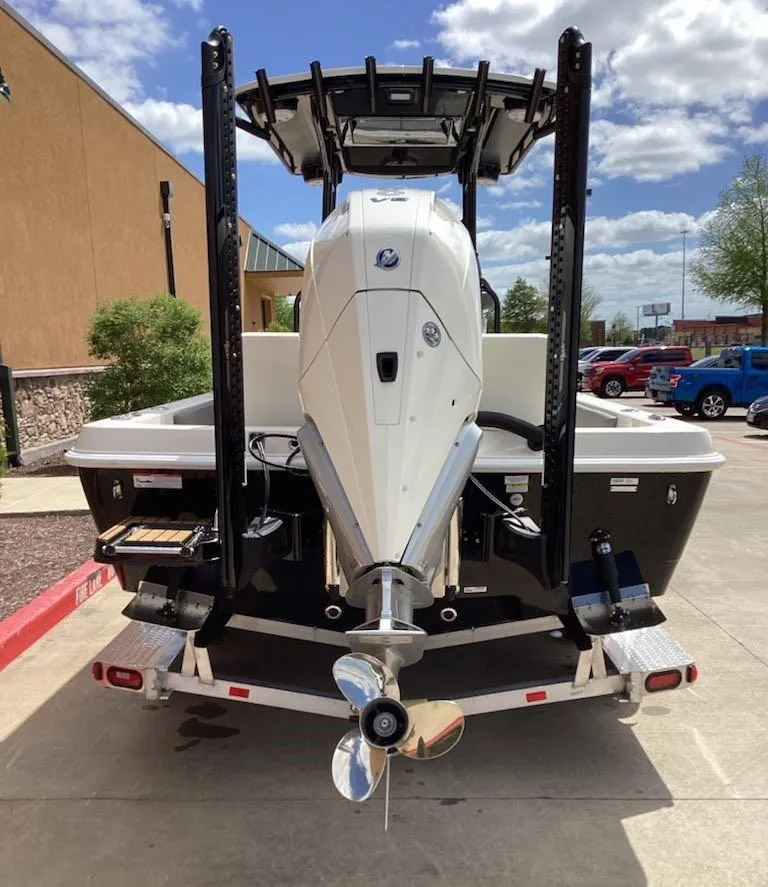 Slide: The Image of 2025 Ranger 2360 Bay boat, rear view with outboard motor, parked outdoors. - 2