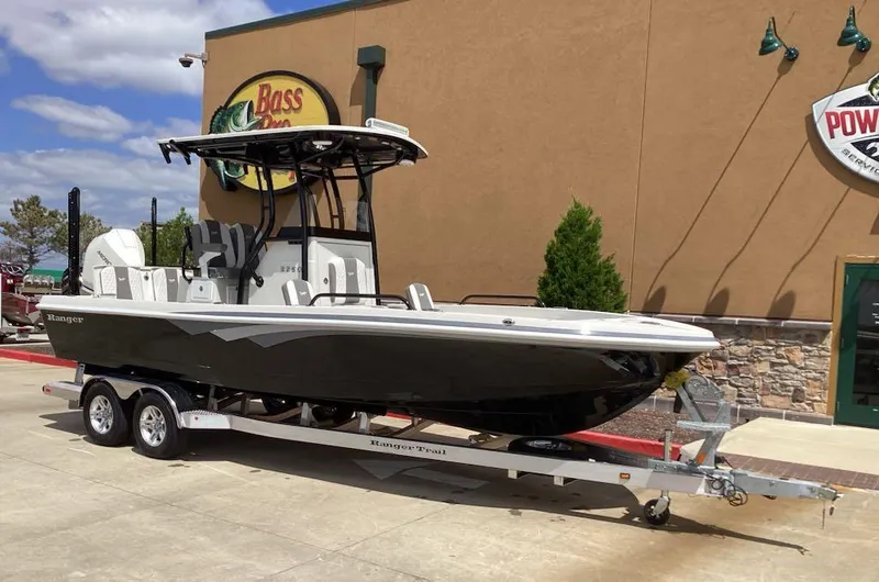 Slide: The Image of 2025 Ranger 2360 Bay boat on trailer outside a store, clear sky background. - 6