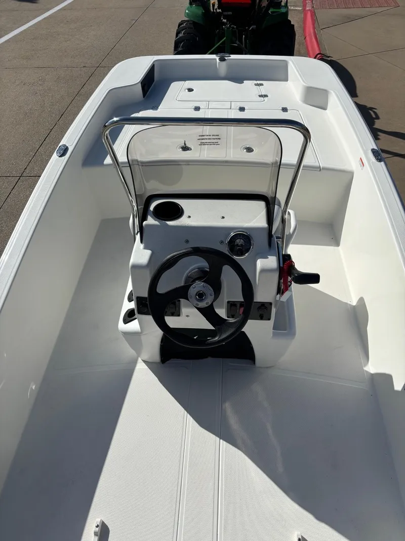 Slide: The Image of 2025 Mako Pro Skiff 15 CC boat interior with steering console and seating area. - 4
