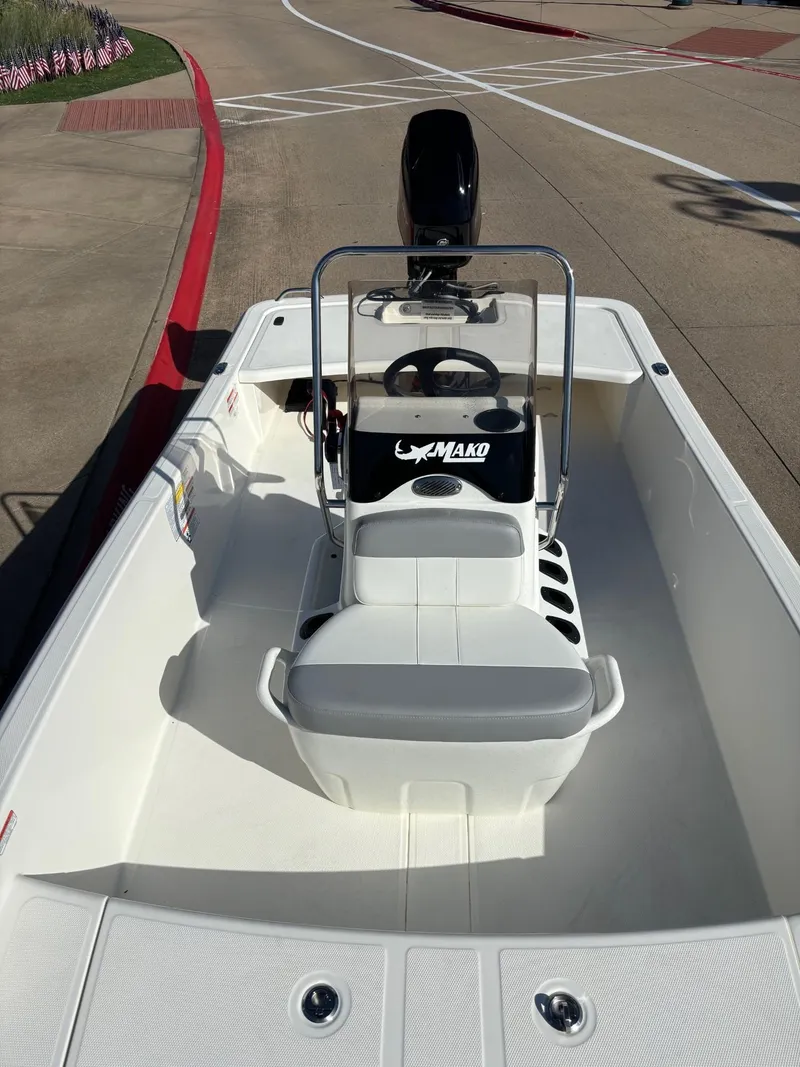 Slide: The Image of 2025 Mako Pro Skiff 15 CC boat, white interior, parked on concrete pavement. - 5