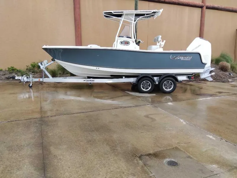 Slide: The Image of 2025 Mako 214 CC boat on trailer, parked on wet pavement. - 0