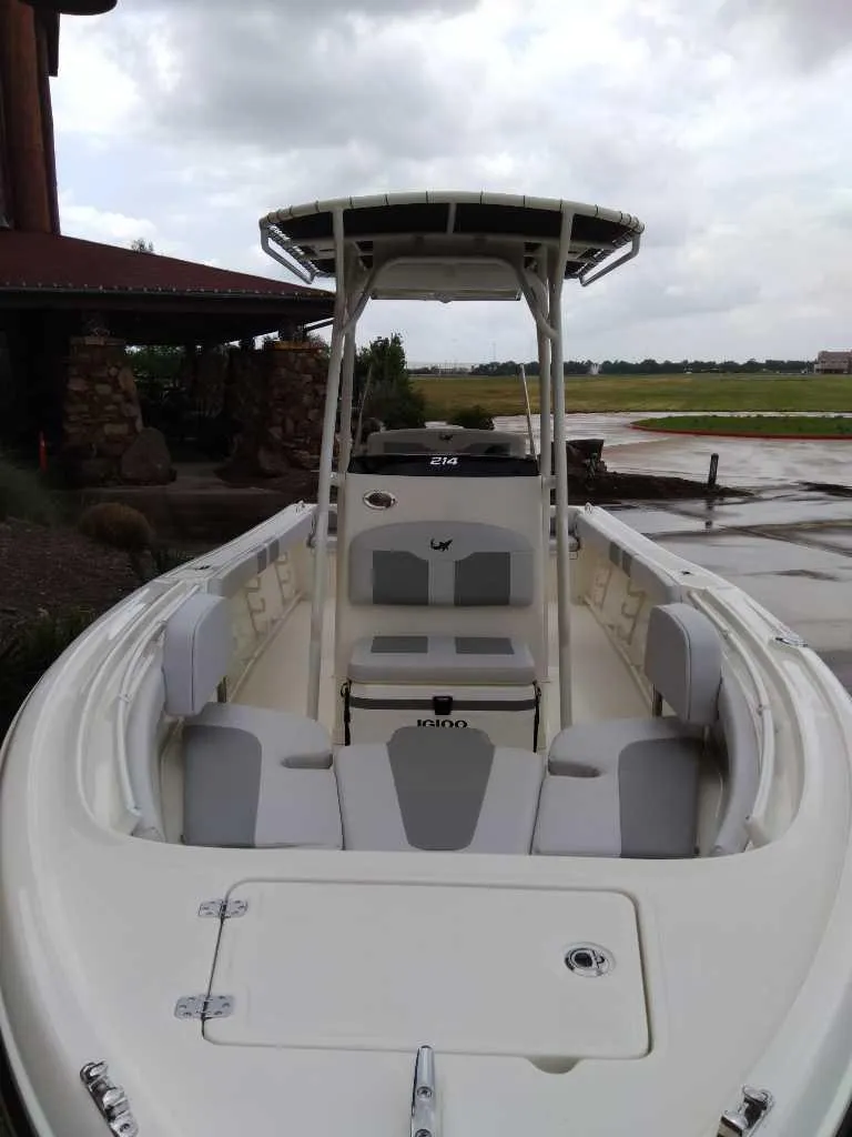 Slide: The Image of 2025 Mako 214 CC boat with seating and T-top under cloudy sky. - 2