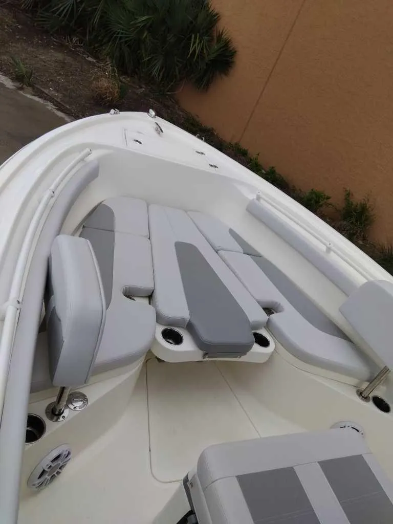 Slide: The Image of 2025 Mako 214 CC boat interior with gray and white cushioned seating. - 5