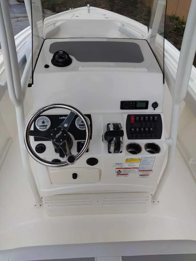 Slide: The Image of 2025 Mako 214 CC boat console with steering wheel and control panel. - 6