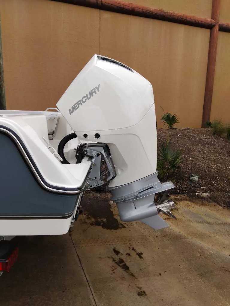 Slide: The Image of 2025 Mako 214 CC boat with Mercury outboard motor, parked on concrete surface. - 7