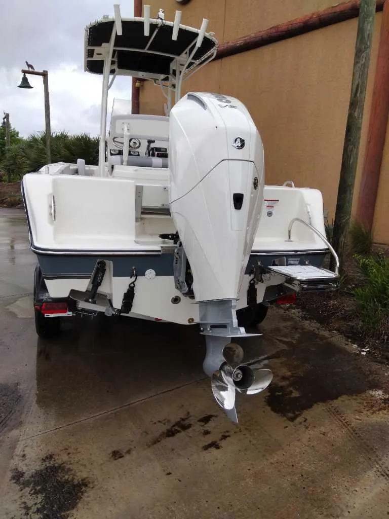 Slide: The Image of 2025 Mako 214 CC boat with outboard motor, parked on wet pavement. - 8