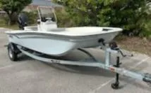 Slide: The Image of 2025 Mako Pro Skiff 15 CC boat on trailer, parked outdoors. - 2