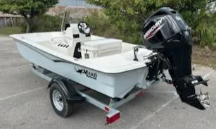 Slide: The Image of 2025 Mako Pro Skiff 15 CC boat on trailer with Mercury outboard motor. - 6
