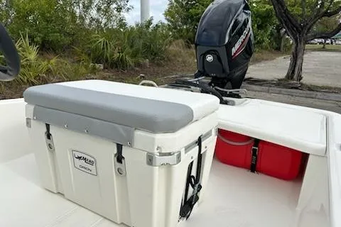 Slide: The Image of 2025 Mako Pro Skiff 15 CC boat with cooler and Mercury outboard motor. - 9