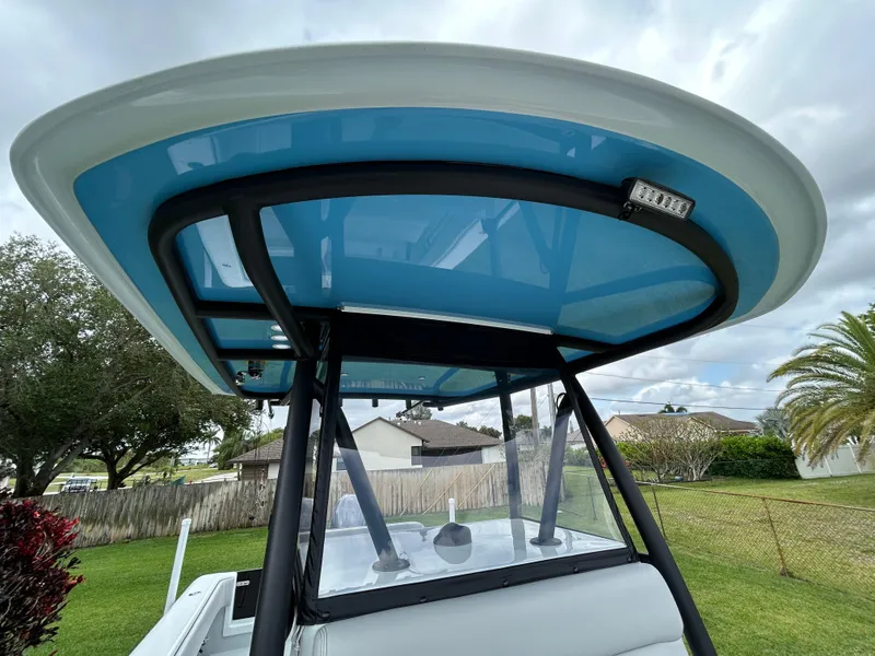 Slide: The Image of 2024 Contender 28 Tournament boat with blue T-top, parked outdoors. - 17