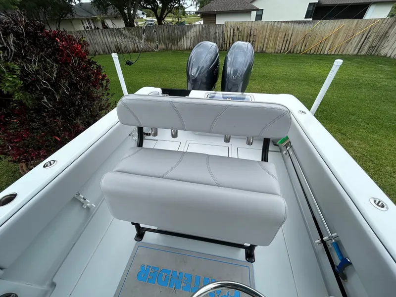 Slide: The Image of 2024 Contender 28 Tournament boat with dual engines and cushioned seating, parked on grass. - 20