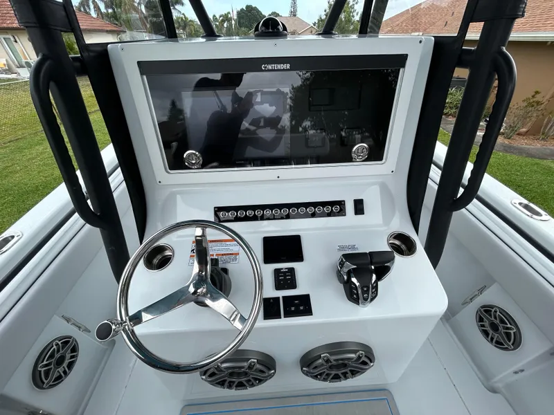 Slide: The Image of 2024 Contender 28 Tournament boat dashboard with steering wheel and control panel. - 23