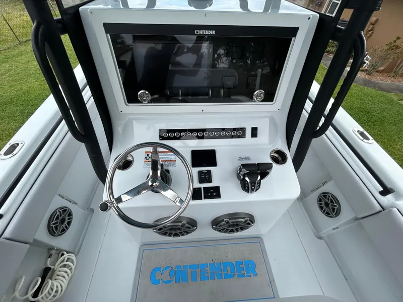 Slide: The Image of 2024 Contender 28 Tournament boat dashboard with steering wheel and controls. - 24