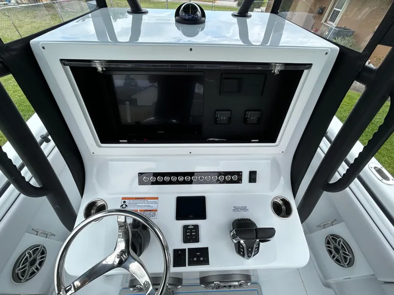 Slide: The Image of 2024 Contender 28 Tournament boat dashboard with steering wheel and control panel. - 25