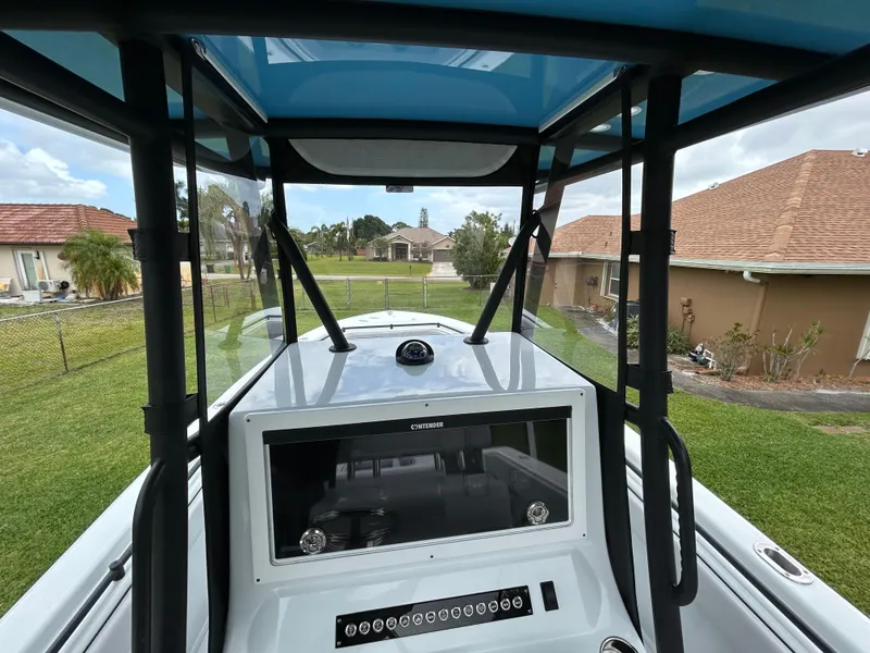 Slide: The Image of 2024 Contender 28 Tournament boat console with T-top, in a residential backyard setting. - 28