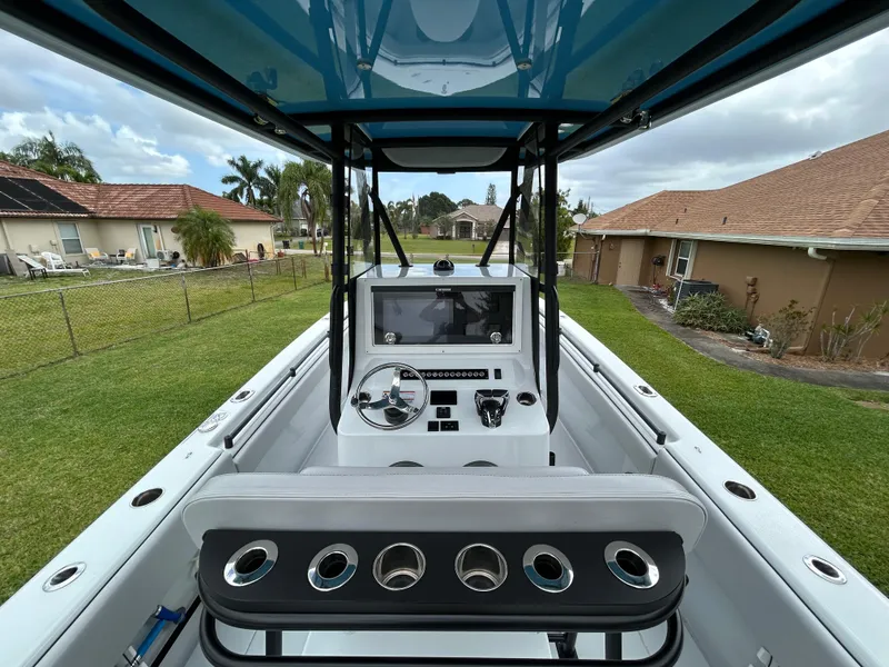 Slide: The Image of 2024 Contender 28 Tournament boat cockpit with steering wheel and control panel, outdoor setting. - 31
