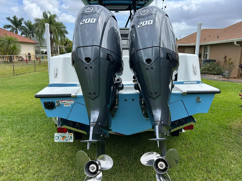 Slide: The Image of 2024 Contender 28 Tournament boat with dual 200 horsepower engines, parked on grass. - 35