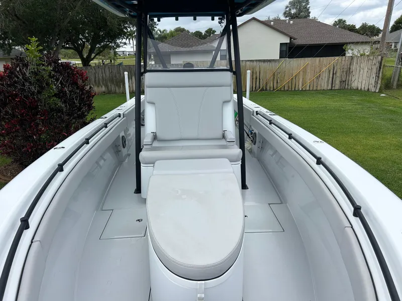 Slide: The Image of 2024 Contender 28 Tournament boat interior with seating and console, parked in a grassy yard. - 8