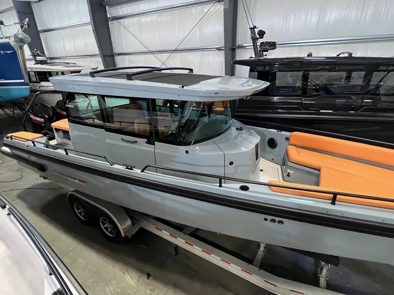Slide: The Image of 2022 BRABUS Shadow 500 Cabin boat with sleek design and orange seating, displayed indoors. - 2