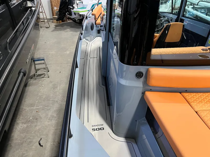 Slide: The Image of 2022 BRABUS Shadow 500 Cabin with orange seating, docked indoors. - 20
