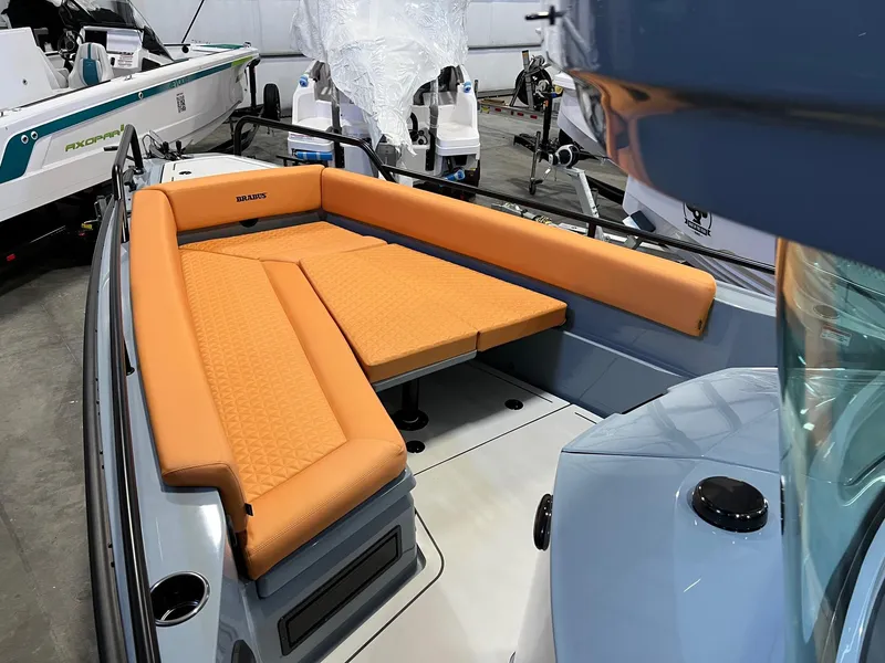 Slide: The Image of 2022 BRABUS Shadow 500 Cabin with orange seating in a showroom. - 21