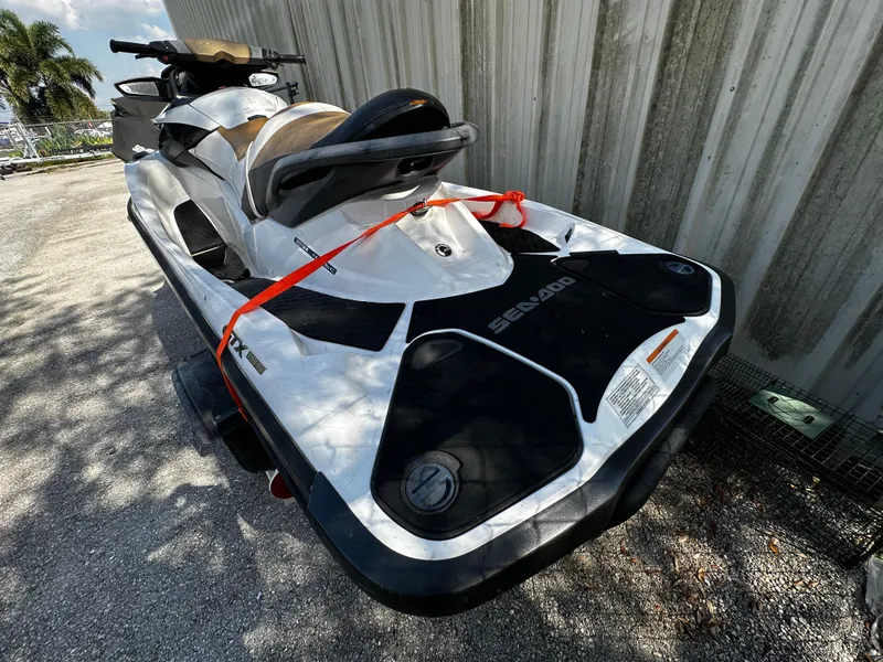 Slide: The Image of 2012 Sea-Doo GTX 155 jet ski parked outdoors, secured with red straps. - 5