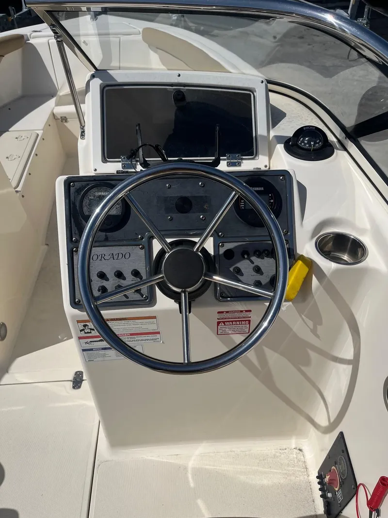 Slide: The Image of 2018 Scout 210 Dorado boat dashboard with steering wheel and control panel. - 3